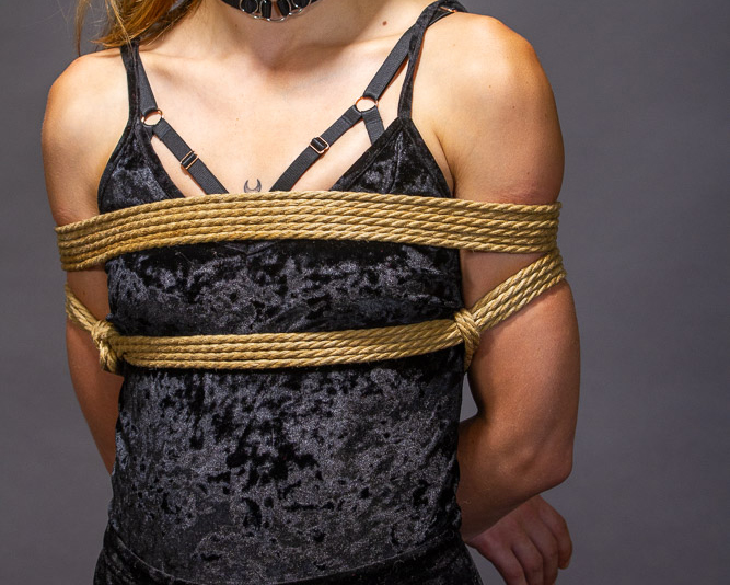 Auf dem Rücken gefesselte Arme - hier in Vorderansicht