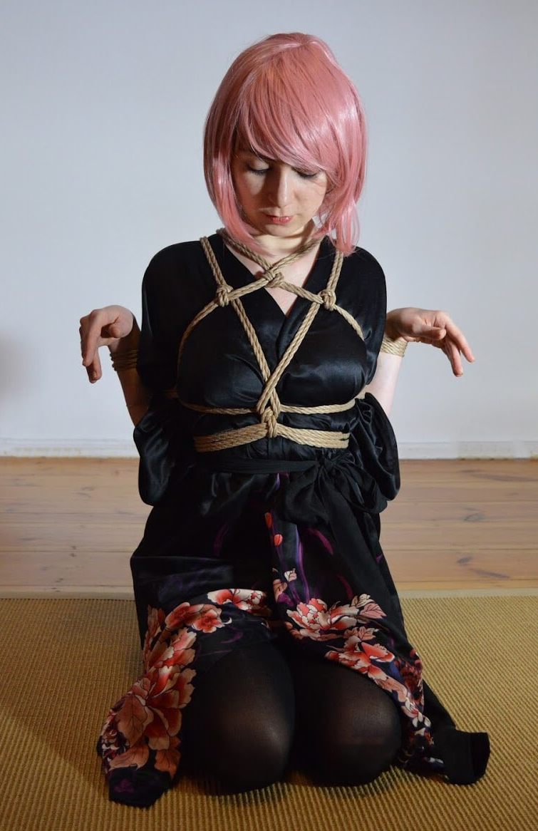 Die Arme sind rechts und links neben dem Körper gefesselt und erinnern an die Flügel des Dämonen Tengu